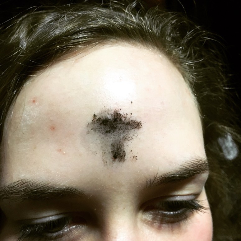 Sign of the cross on a woman's forehead.